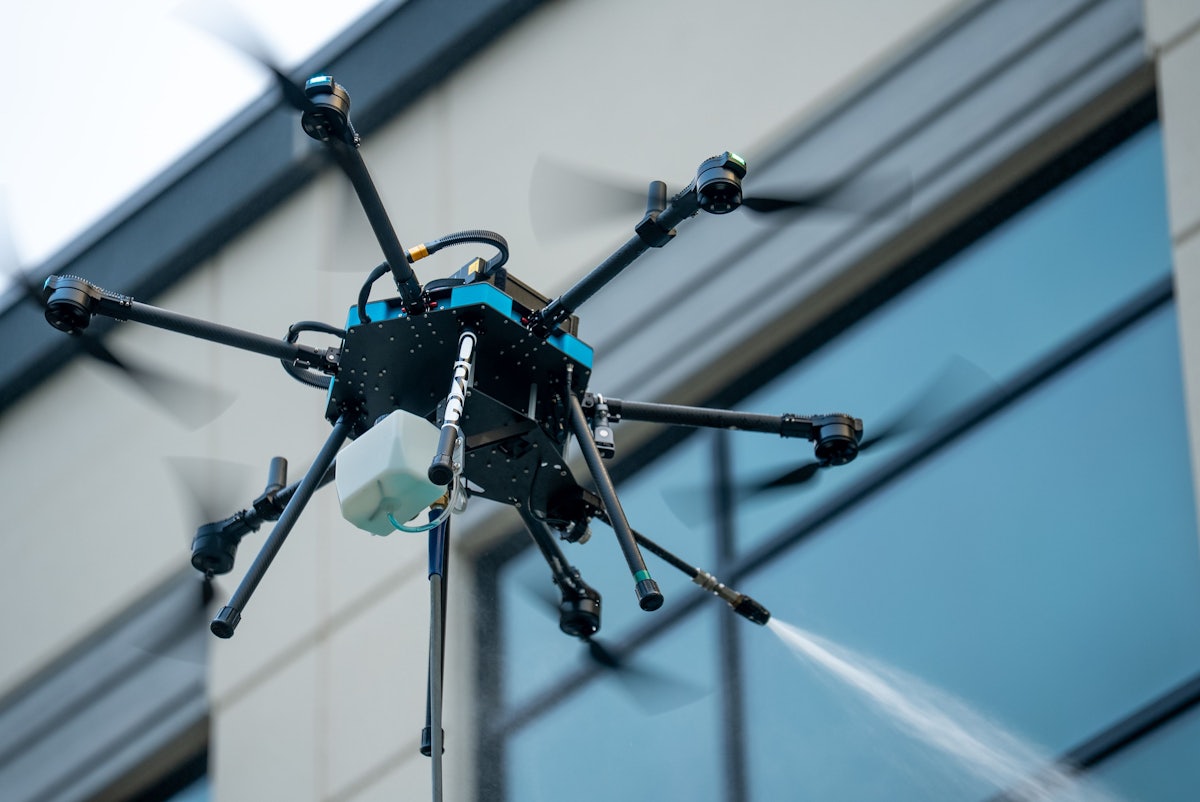 Drone with a spray system cleaning exterior building windows