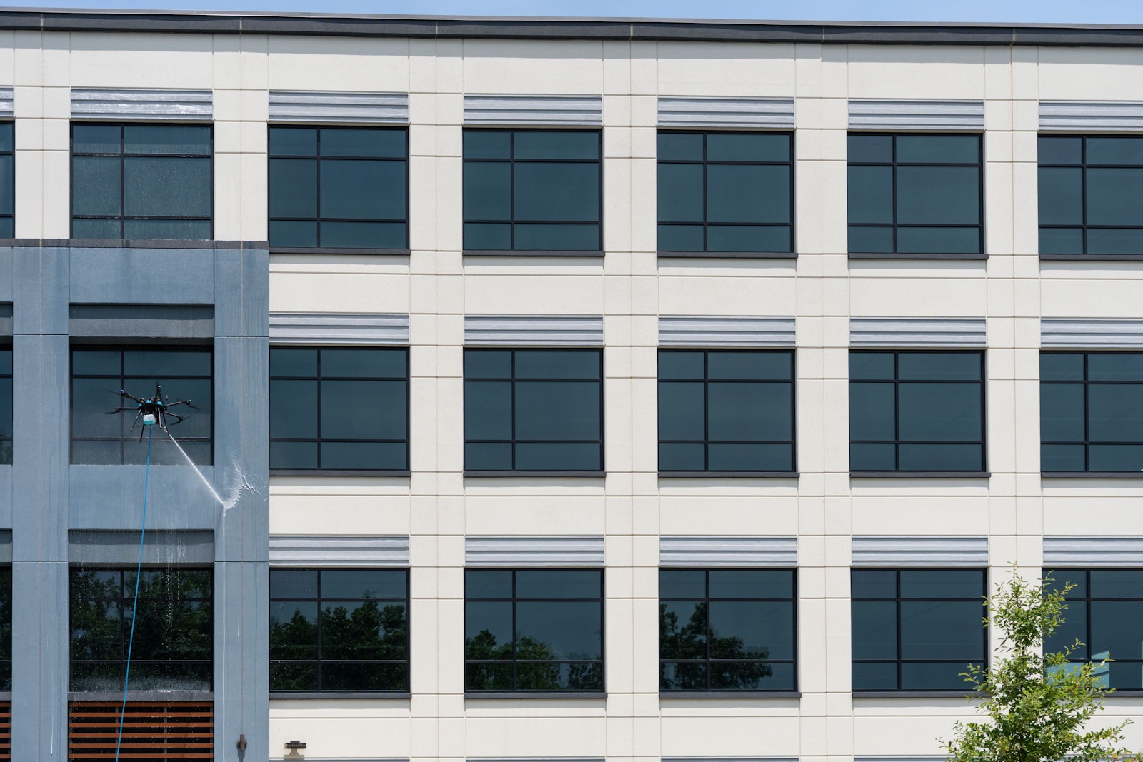 Sherpa drone cleaning the upper windows of a modern office building